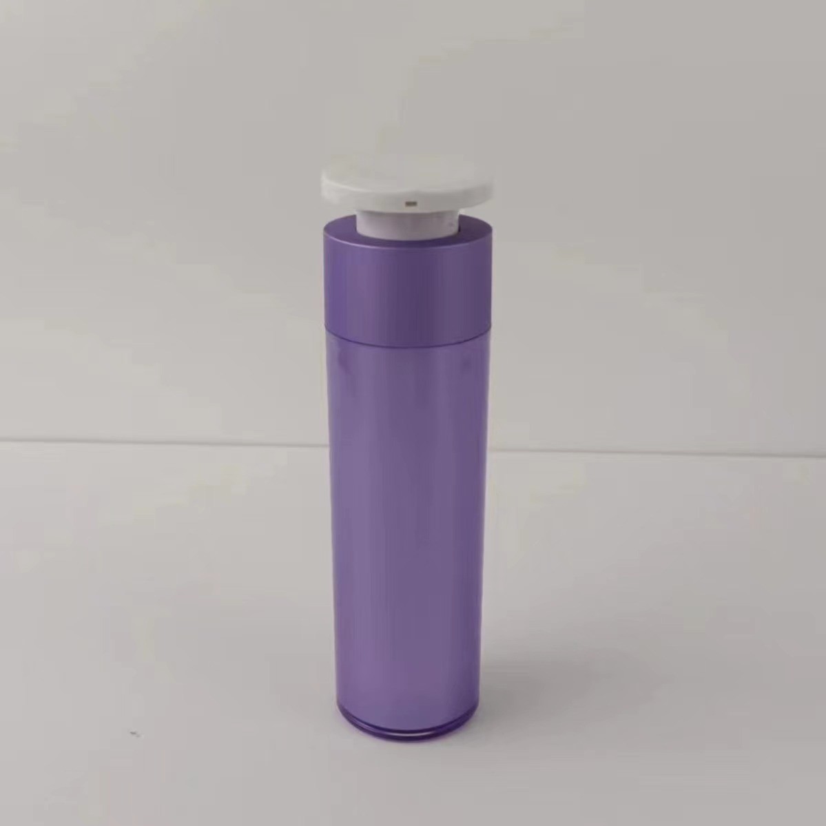 Bottiglia per distributori cosmetici di plastica viola con pompa di pressione bianca